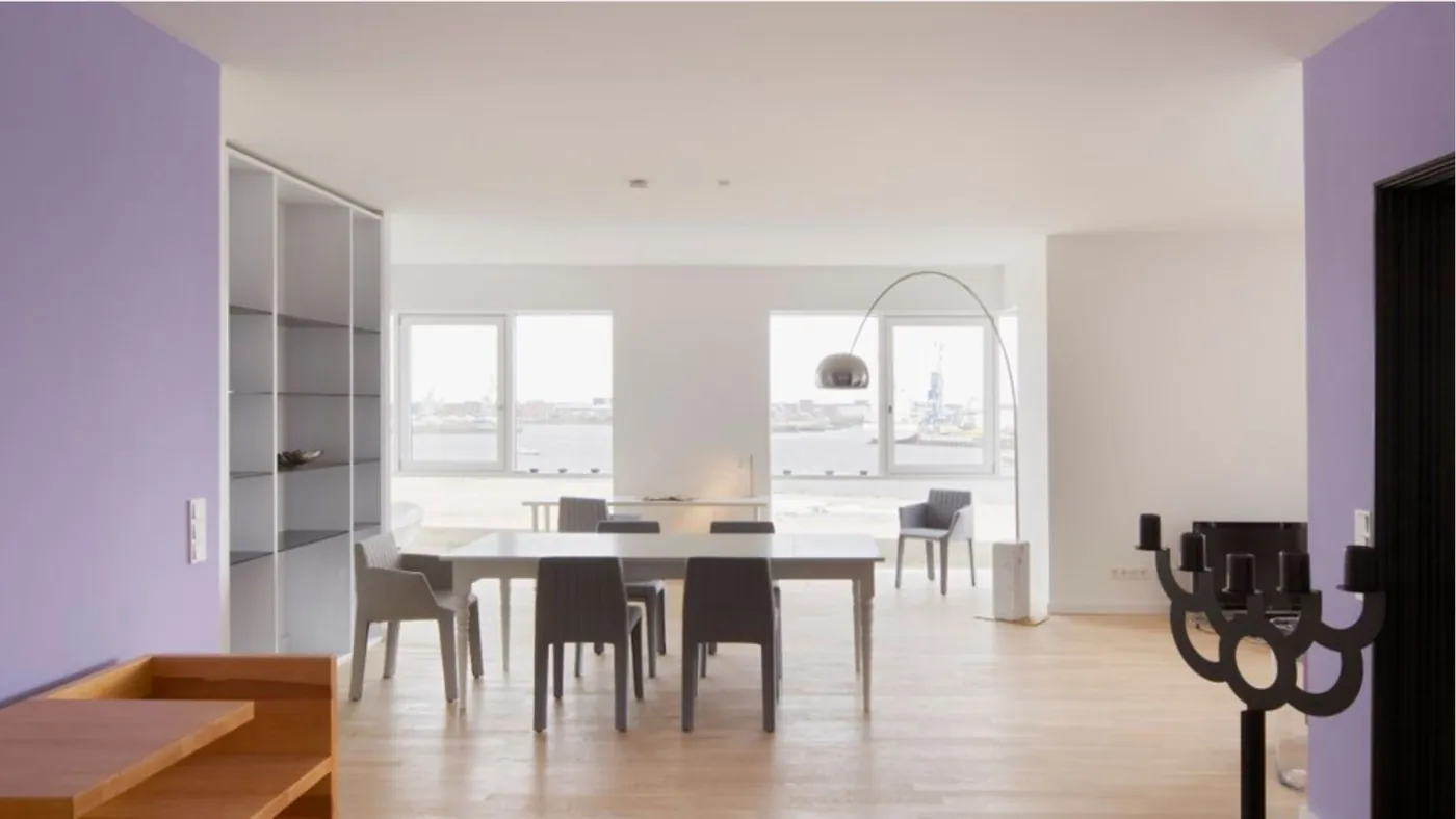 Open-plan dining room with a long table and bright windows